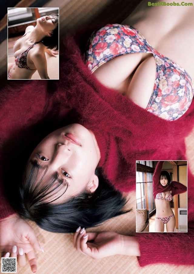 A woman in a red sweater laying on a bed.