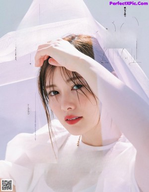 A woman with long brown hair is posing for a magazine.