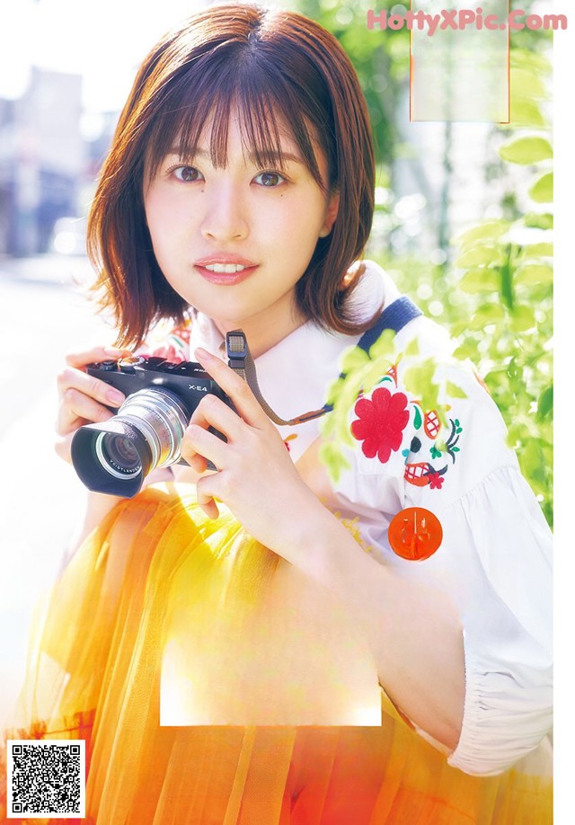 A woman holding a camera in front of her face.