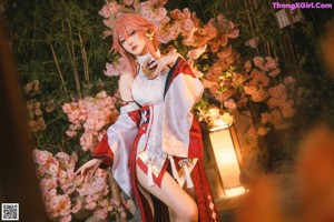 A woman with pink hair sitting on a wooden bench.