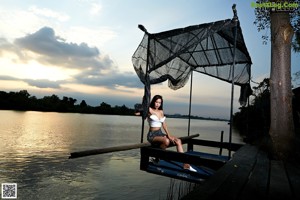 A woman in a white bikini sitting on a boat.