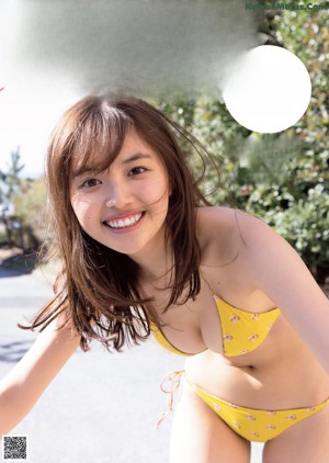 A woman in a black and white striped bikini posing for a picture.