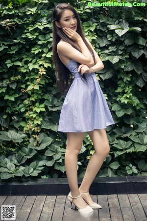 A woman in a blue and white striped dress posing for a picture.