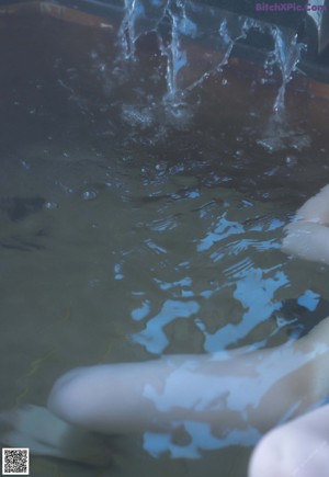 A close up of a woman's breast with water droplets on it.