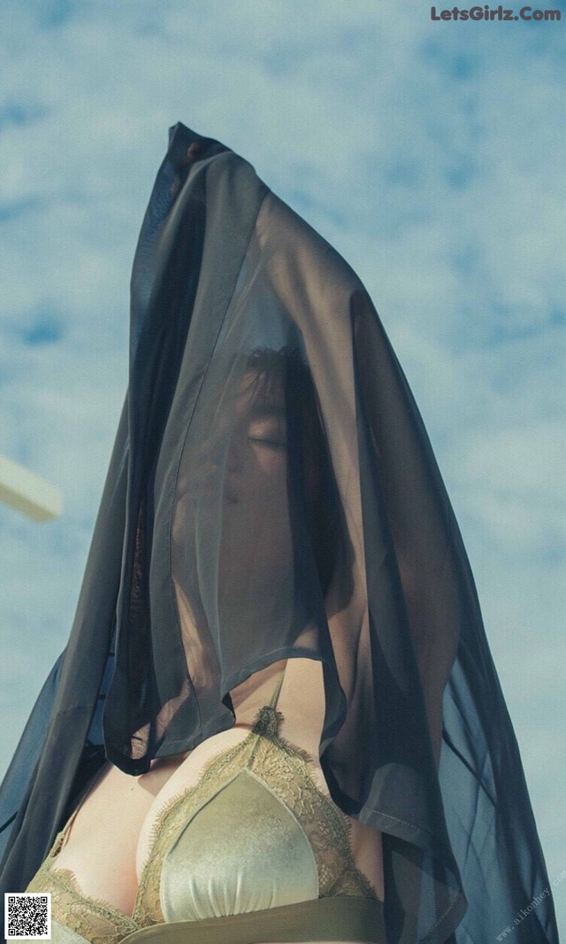 A woman wearing a black veil over her head.