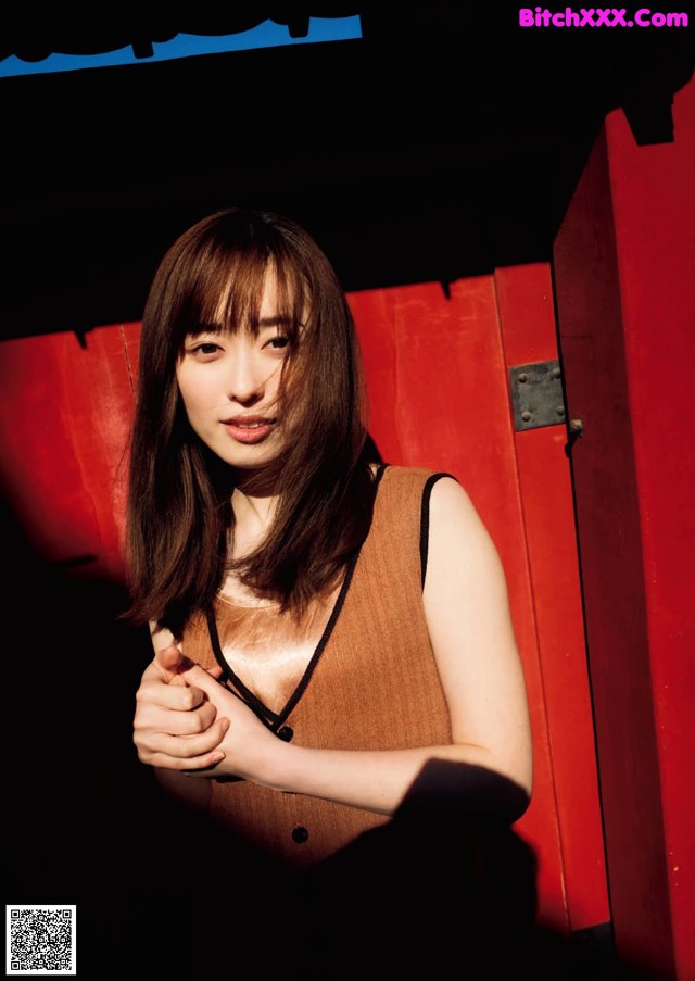 A woman standing in front of a red door.