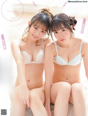 Two young women in lingersuits sitting on the floor.