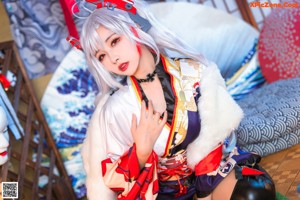 A woman in a kimono sitting on the floor.