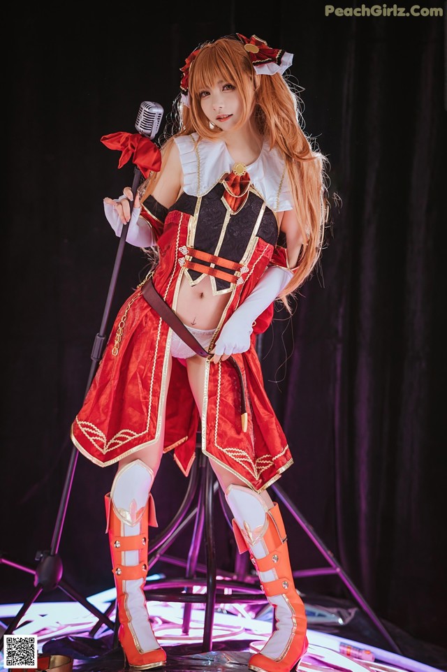 A woman in a red and white outfit holding a microphone.