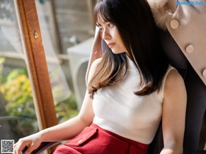 A woman sitting on a couch next to a heater.