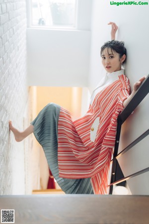 A woman wearing a red and white striped shirt and a pair of earrings.