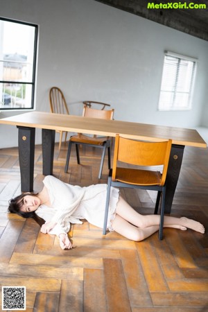 A woman sitting on the floor holding a mirror.