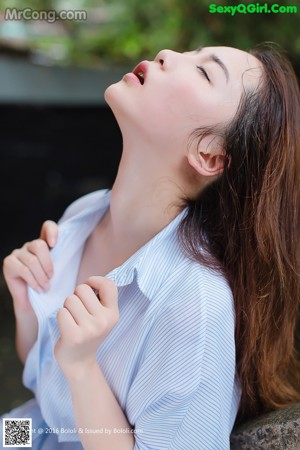 A woman sitting on the ground with her head in her hands.