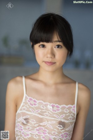 A naked asian woman leaning against a white wall.