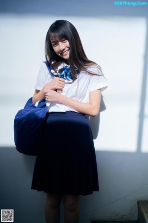 A woman sitting on a wooden bench with her legs crossed.