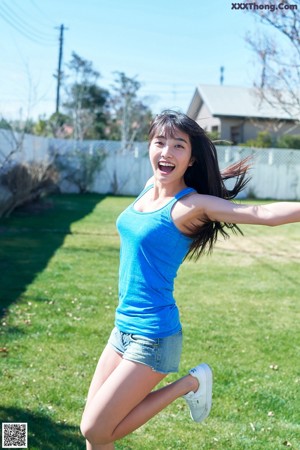 A woman in a school uniform with a blue backpack.