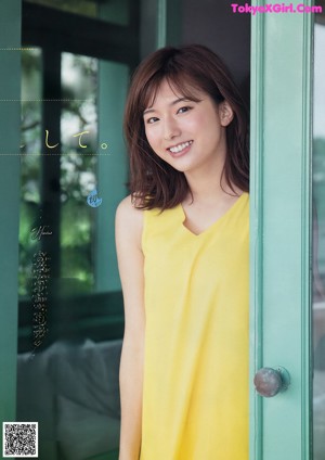 A woman sitting on the floor next to a glass of orange juice.