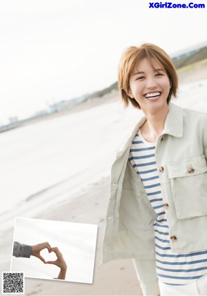 A woman in a blue and white dress and a white jacket.